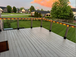 Finished wire deck railing with lights at sunset